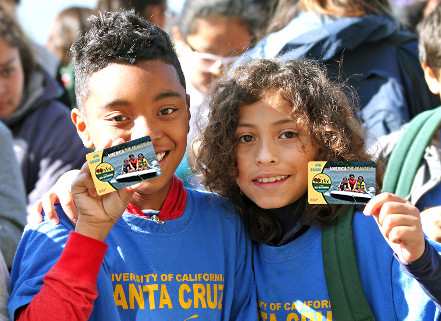 children holding up park passes